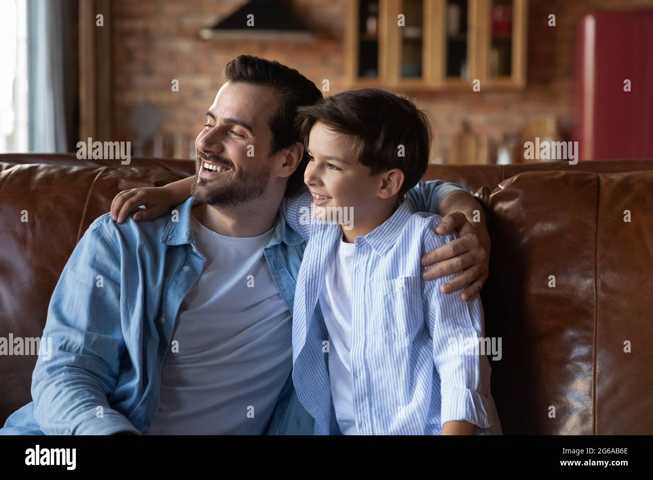 Bon fils et papa d'avant-garde assis ensemble sur un canapé Banque D'Images