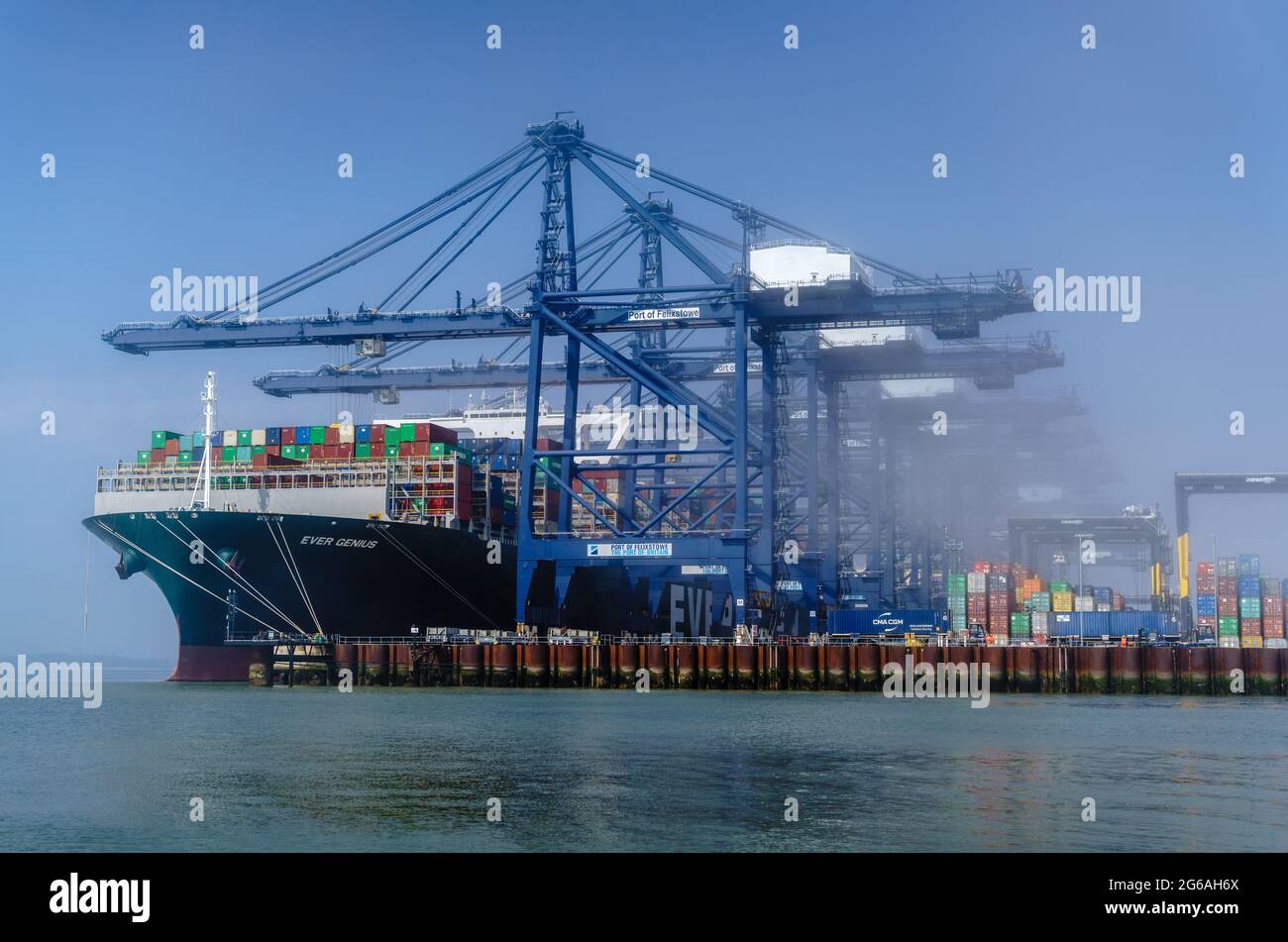 Commerce - les conteneurs déchargent pendant la brume matinale au port de Felixstowe, le plus grand port de conteneurs du Royaume-Uni. Banque D'Images