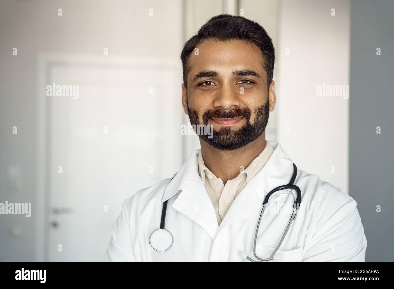 Portrait en gros plan de jeune homme confiant médecin thérapeute en robe médicale blanche Banque D'Images