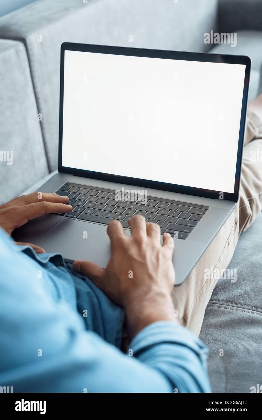 Gros plan sur un ordinateur portable blanc écran vide avec main mâle sur le clavier Banque D'Images