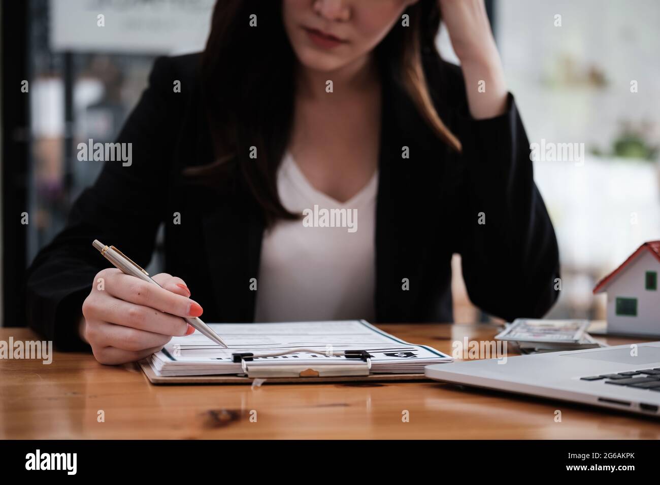 Une femme stressée signe un contrat pour annuler son appartement de location et payer un paiement en souffrance. Banque D'Images