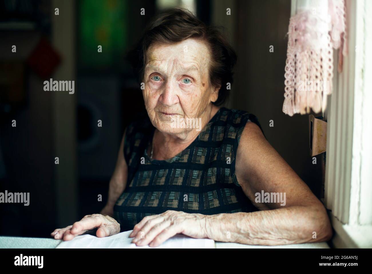 Une vieille femme, un portrait dans sa maison. Banque D'Images