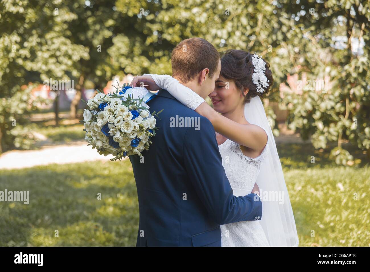 Bélarus, région de Minsk - 11 août 2018 : mariage. Les hugs et la tendresse de la mariée heureuse et marié sur une promenade dans le parc extérieur arrière-plan. Banque D'Images