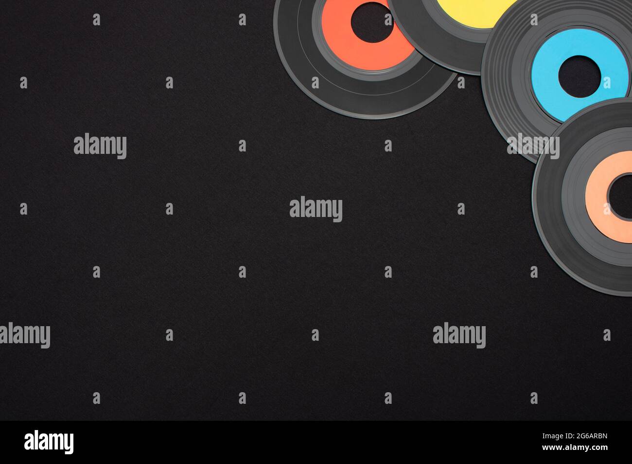 Vinyle simple multicolore de 7 pouces enregistre sur fond noir avec un espace vide pour le texte. Vue de dessus vers le bas, plan d'appartement avec orientation horizontale Banque D'Images