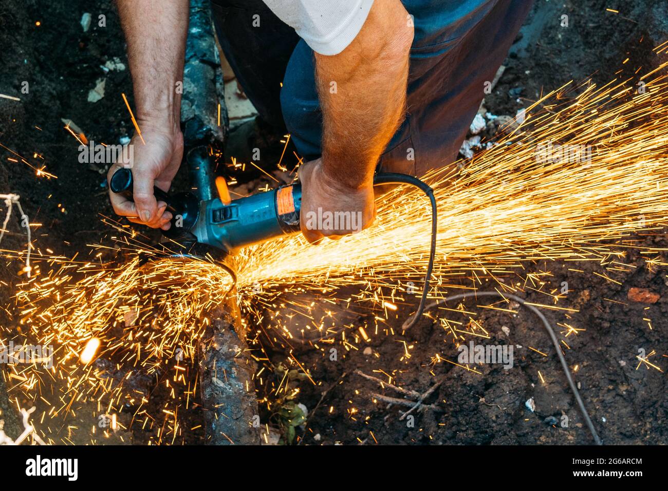 L'employé coupe le tuyau de gaz avec une meuleuse et beaucoup d'étincelles volent. Banque D'Images