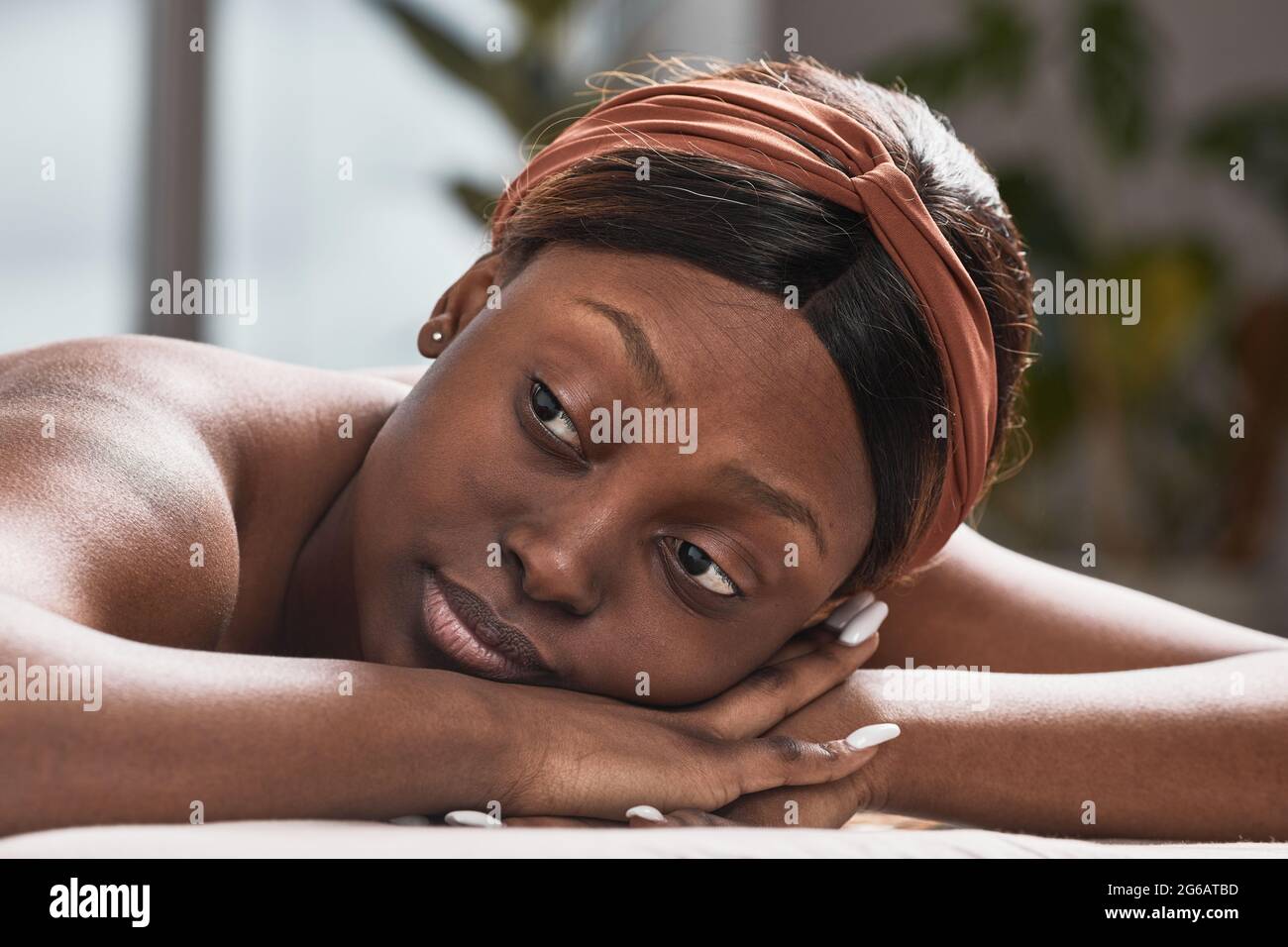 Portrait d'une jeune femme afro-américaine allongé sur une table de massage et bénéficiant de soins de beauté, espace de copie Banque D'Images