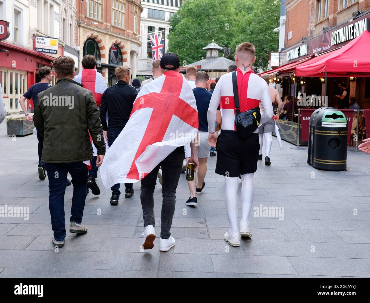 Les supporters d'Angleterre portant les croix de St George traversent le West End avant le match contre l'Ukraine. Banque D'Images