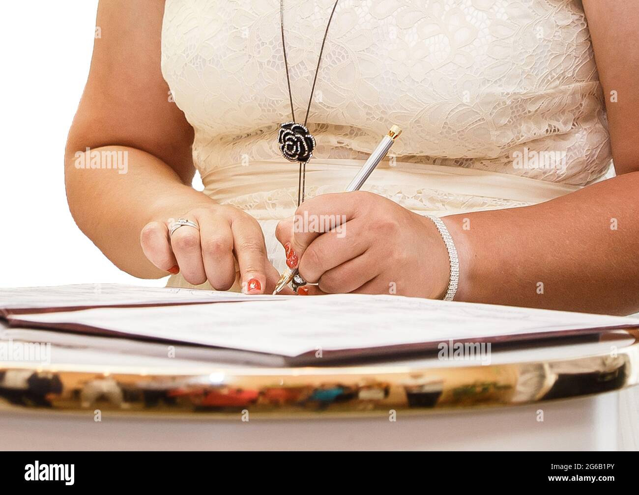 Les mains de la fille au mariage ont mis leur stylo signature dans le magazine au sujet de l'enregistrement du mariage. Banque D'Images