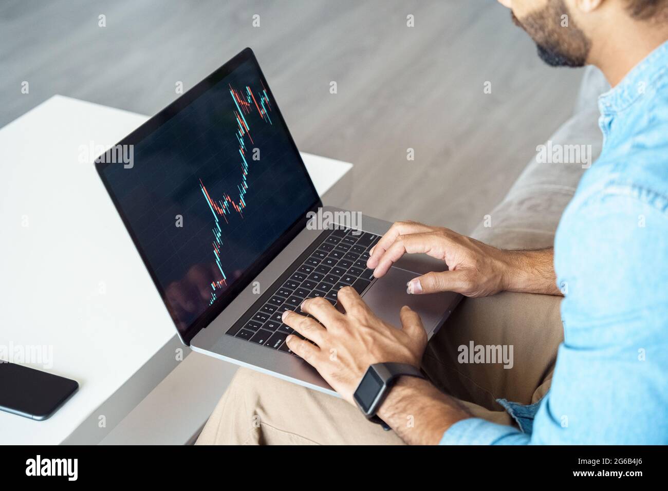 Gros plan sur la main masculine travaillant sur ordinateur portable avec graphique de bougie pour le marché boursier Banque D'Images