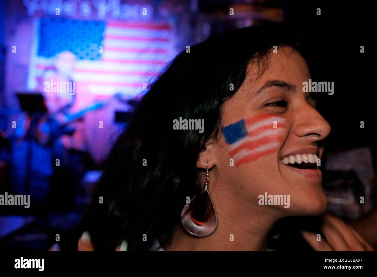 Le drapeau américain est peint sur le visage d'une jeune femme lors de la fête de l'indépendance du 4 juillet aux États-Unis, au pub Mike's place, le 4 juillet 2021 à Jérusalem, en Israël. Banque D'Images