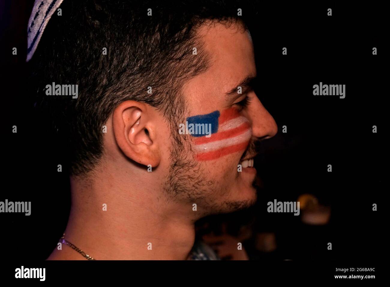 Le drapeau américain est peint sur le visage d'un jeune homme lors de la célébration du jour de l'indépendance du 4 juillet 2021 à Jérusalem, en Israël. Banque D'Images