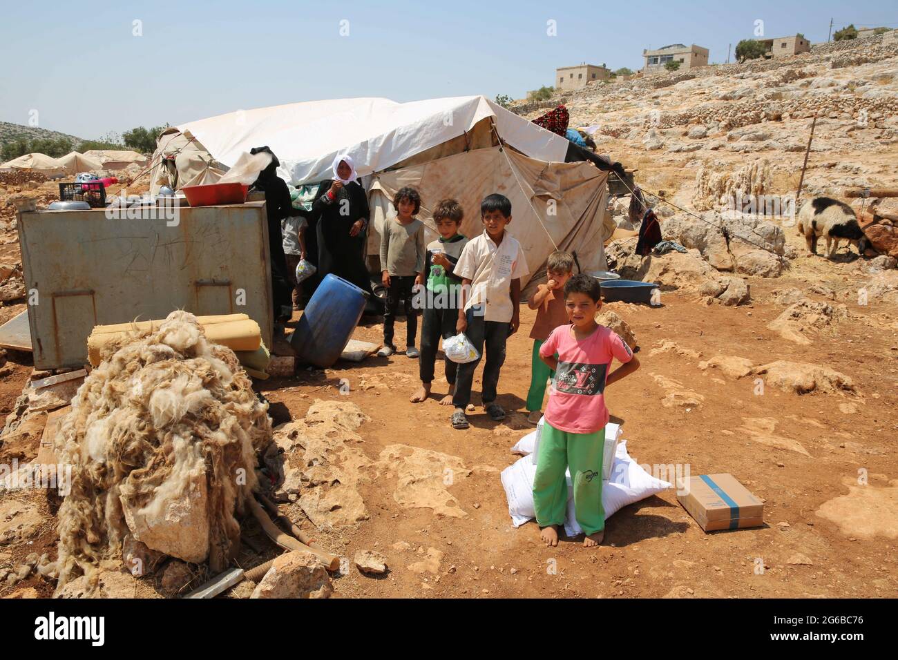 4 juillet 2021 : Alep, Syrie, 04 juillet 2021. Enfants dans un camp de personnes déplacées à Datrat Izza, au nord-ouest d'Alep. Plus de 2 millions de personnes déplacées vivent dans le nord-ouest de la Syrie, souvent dans des camps surpeuplés dépourvus d'infrastructures et d'installations de base. Ils comptent beaucoup sur la distribution de l'aide qui les atteint par le passage de Bab al-Hawa depuis la Turquie comme la seule voie autorisée pour l'aide humanitaire coordonnée par l'ONU. Les organisations humanitaires ont averti qu'une énorme crise humanitaire serait confrontée aux personnes déplacées, mais aussi au reste de la population dans la région nord-ouest de la Syrie si l'ouverture était possible Banque D'Images