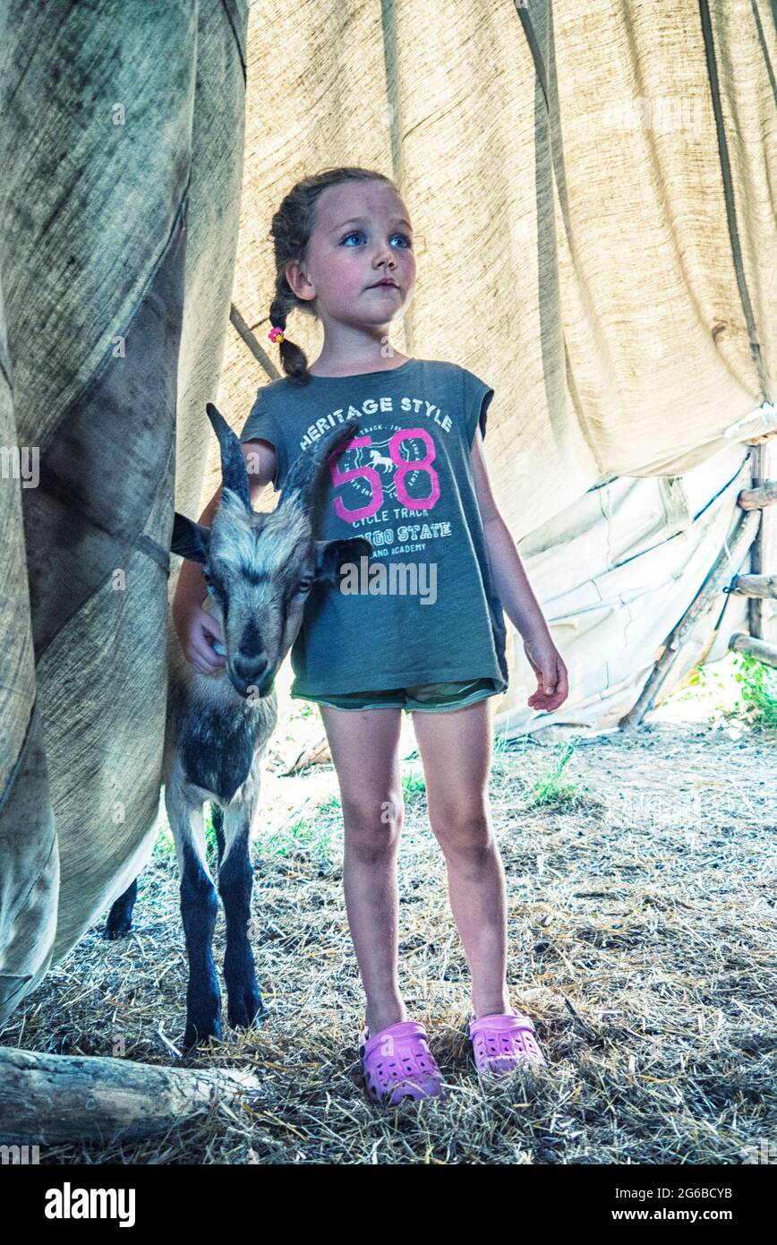 Fille debout dans une tente avec une chèvre, Pologne Banque D'Images
