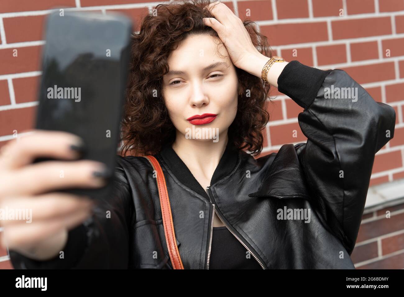 Belle femme debout dans la rue prenant une photo d'elle-même Banque D'Images