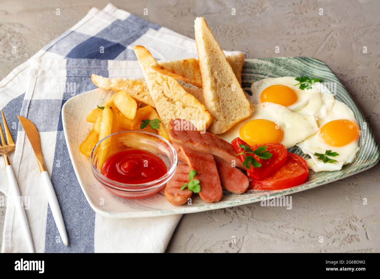 Petitdéjeuner anglais avec œufs, saucisses, toasts français et quartiers de pommes de terre sur