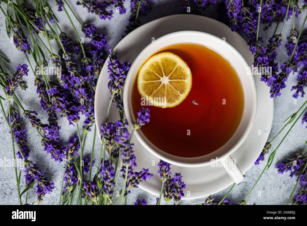Tasse de thé avec une tranche de citron, fleurs de lavande et une étiquette du matin sur une table Banque D'Images