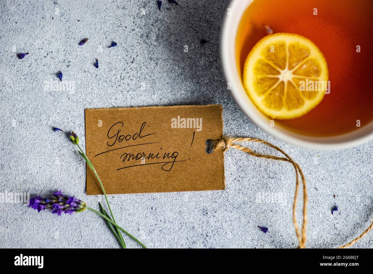 Tasse de thé avec une tranche de citron, fleurs de lavande et une étiquette du matin sur une table Banque D'Images