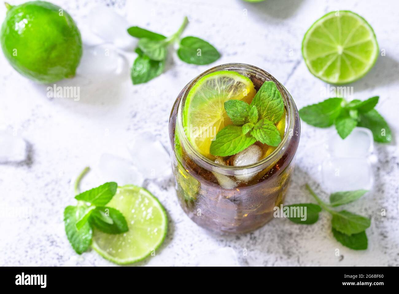 Boisson fraîche d'été rafraîchissante. Boisson alcoolisée Cuba libre, Cola avec glaçons sur table en pierre grise. Banque D'Images