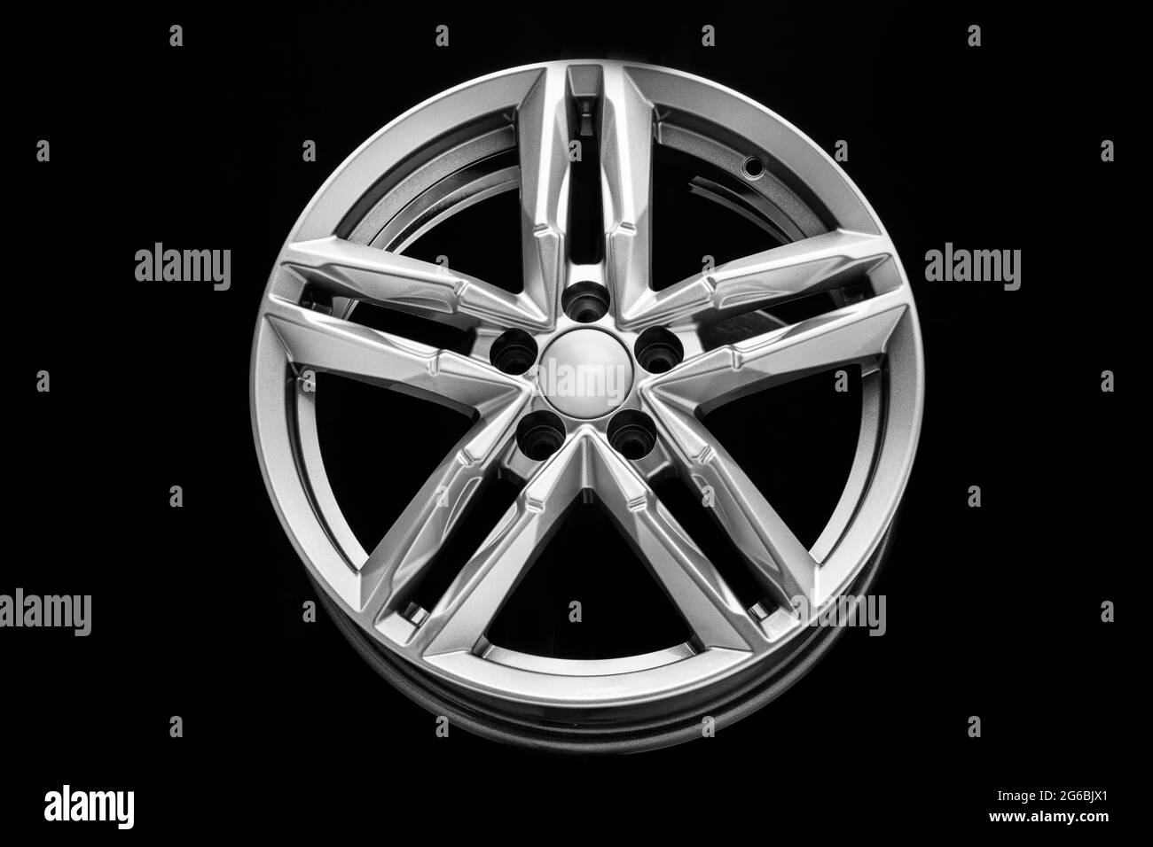 roue en alliage d'argent avec poutres bifurquées sur fond noir. Banque D'Images
