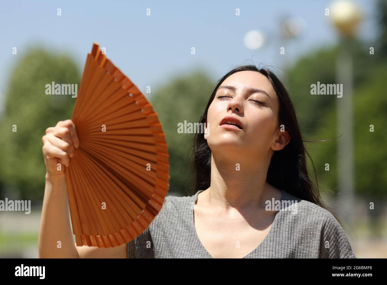 Femme asiatique stressée qui souffrait d'un coup de chaleur dans la rue par une chaude journée d'été Banque D'Images