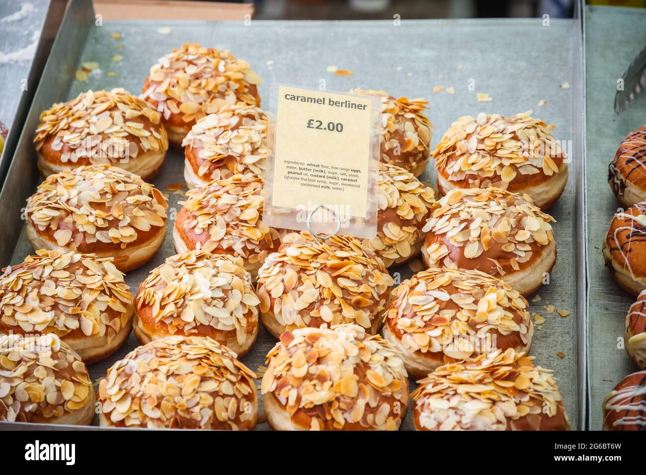 Caramel berliners, beignets allemands, exposés au marché de Broadway, un marché de rue à Hackney, dans l'est de Londres Banque D'Images