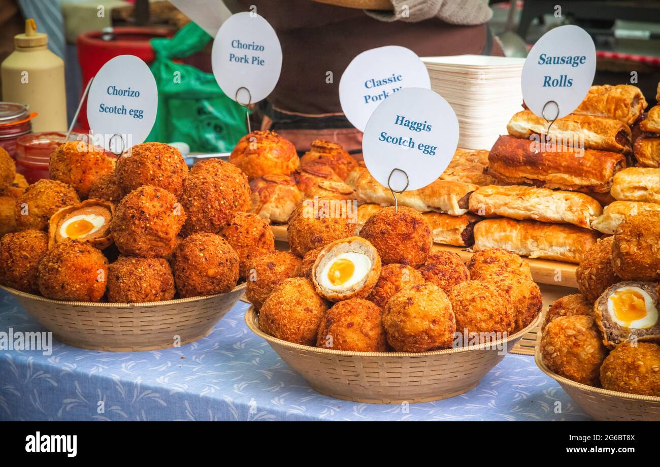 Une variété d'œufs de scotch et d'autres pâtisseries savoureuses en-cas exposés au marché de Broadway, un marché de rue à Hackney, dans l'est de Londres Banque D'Images