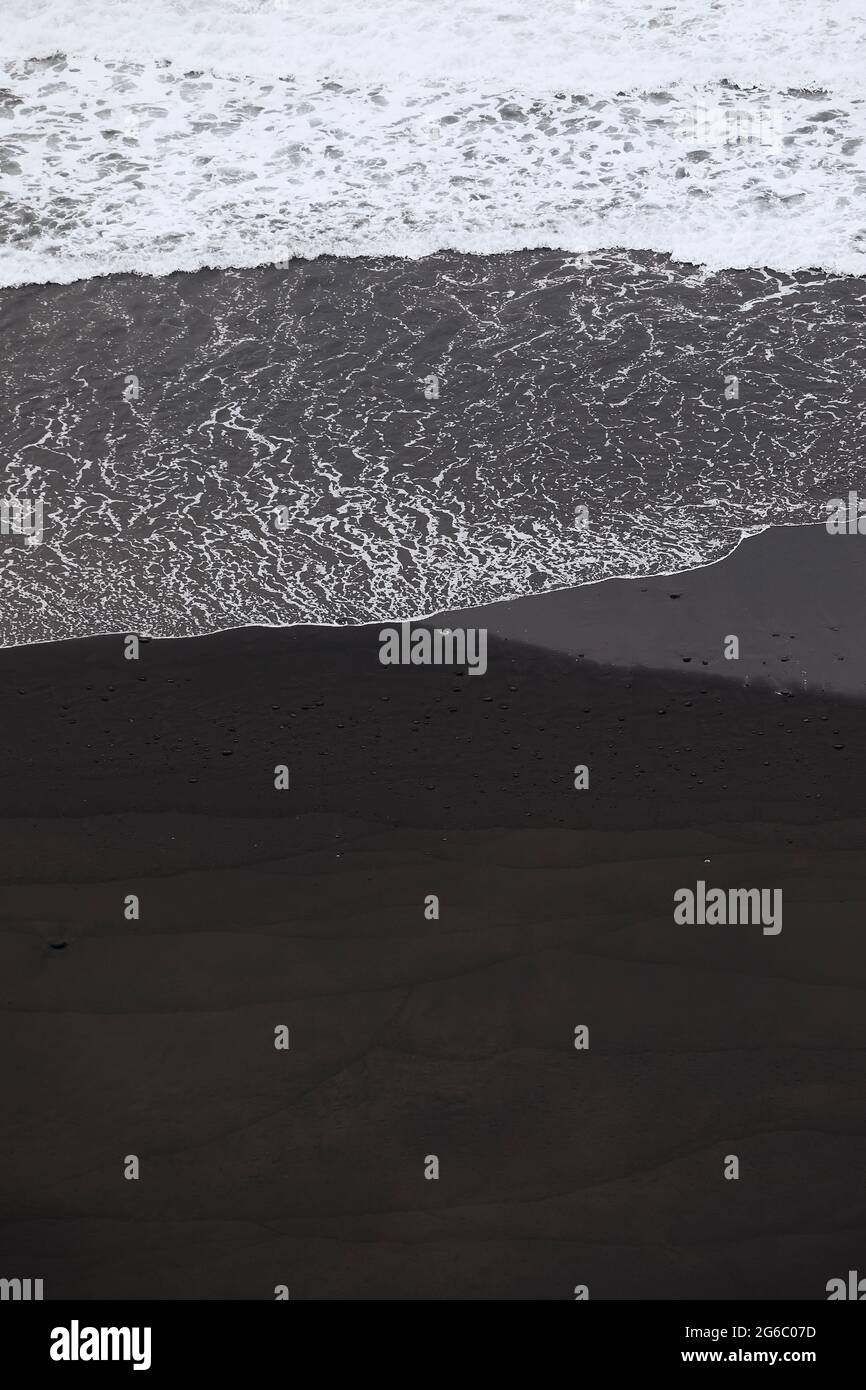 Vagues sur plage de sable noir avec espace de copie. Beauté dans la nature à Ténérife. Îles Canaries, Espagne. Banque D'Images