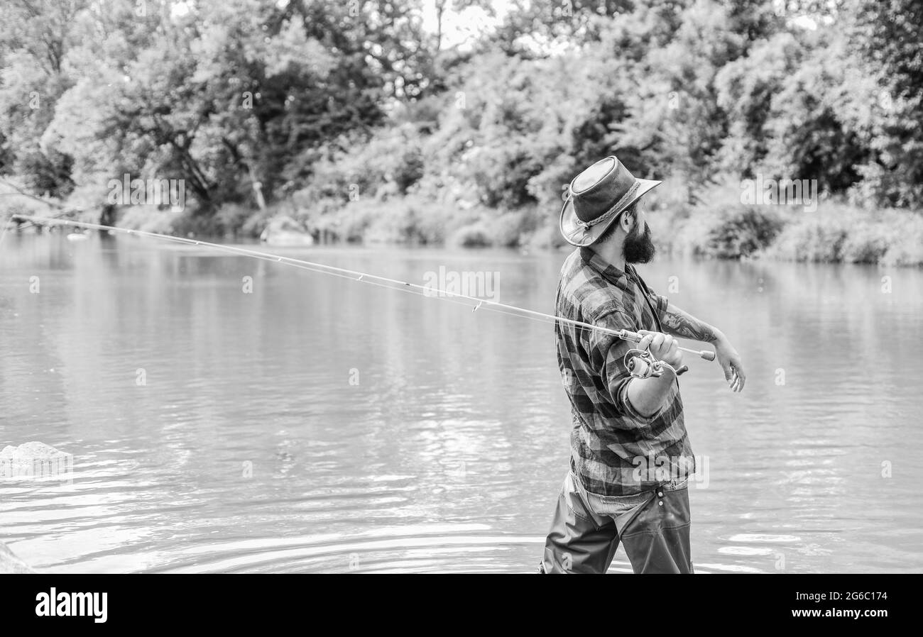 Histoires de poissons racontées ici. Activités de loisir et de sport. Pothunter. Pêcheur barbu dans l'eau. Week-end d'été. Pêche au gros gibier. Homme mature pêche à la mouche. Homme Banque D'Images