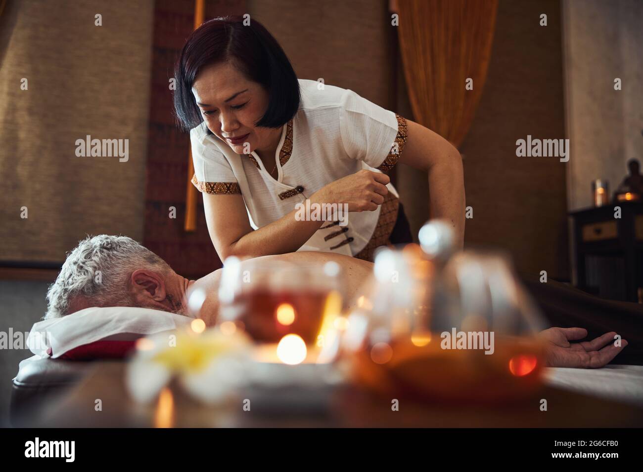 Femme asiatique gaie qui traite l'homme dans le salon de massage Photo  Stock - Alamy