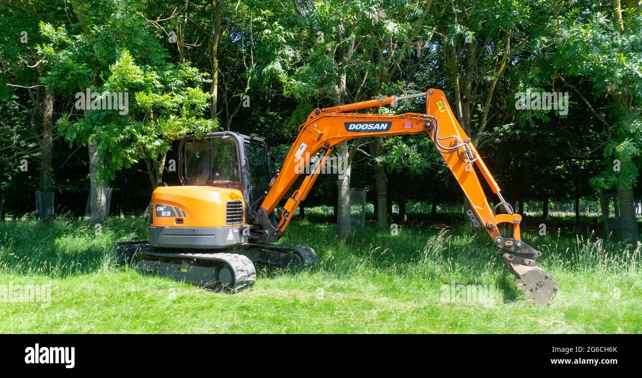 La pelle sur chenilles DX63 de Doosan travaille ici dans une zone de parc. Banque D'Images