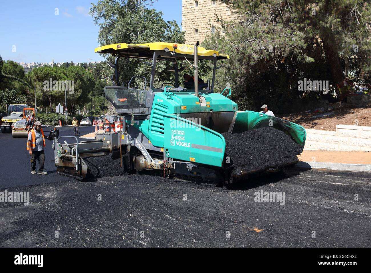 Finisseur finisseur Finisseur pose la première couche d'asphalte sur la route à récurer dans le projet de rénovation de la route du quartier de Beit Hakerem. Jérusalem. Banque D'Images