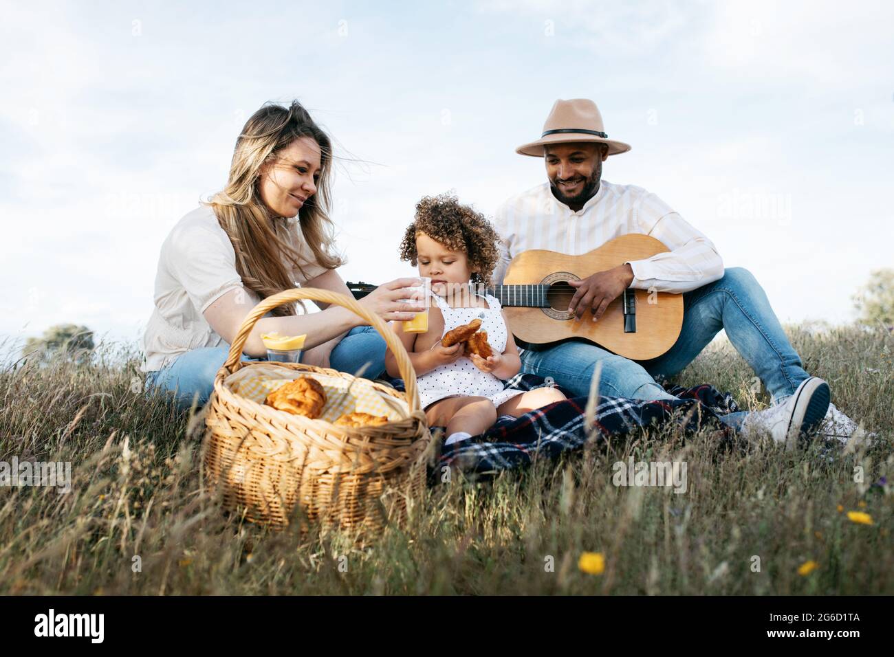 Nous avons ravi toute la famille multiraciale en dégustant un pique-nique ensemble tout en dégustant des en-cas et en jouant de la guitare dans la nature Banque D'Images