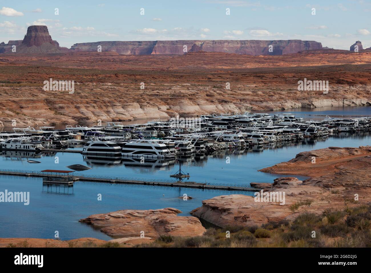 Page, Arizona, États-Unis - 31 octobre 2014 : une rangée de bateaux de croisière touristique amarrés dans la marina d'Antelope point sur le lac Powell avec Tower Butte et Navajo Banque D'Images