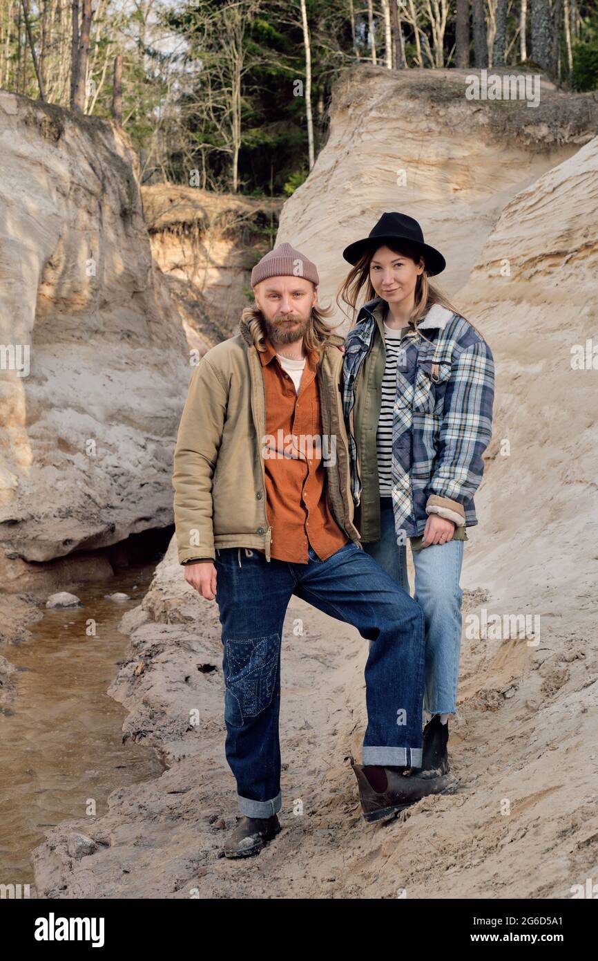 Portrait d'un jeune couple de randonneurs tenant les mains et regardant la caméra tout en se tenant sur les rochers Banque D'Images