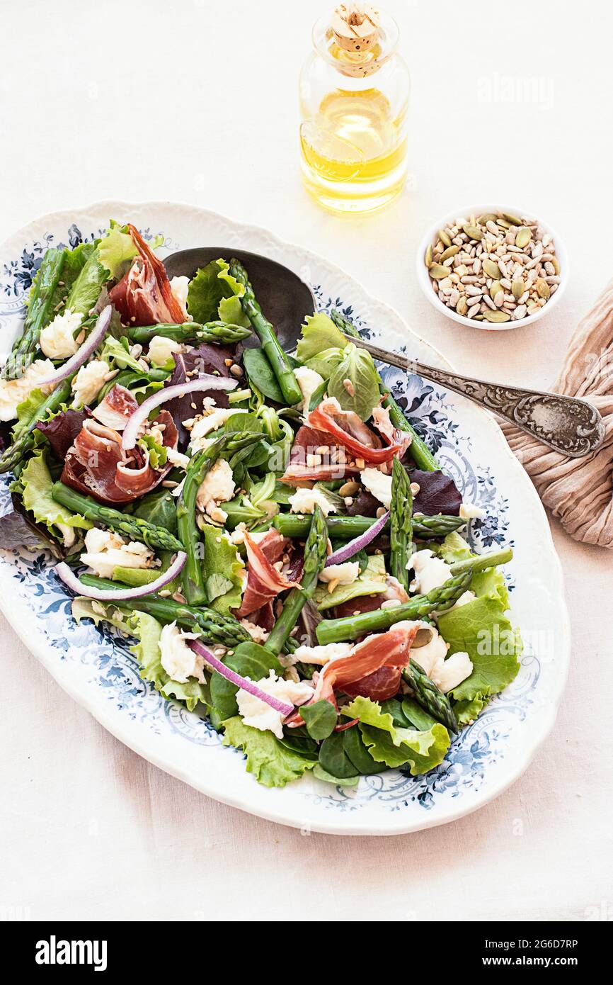 De dessus délicieux prosciutto, mozzarella et salade d'asperges sur fond blanc de table Banque D'Images