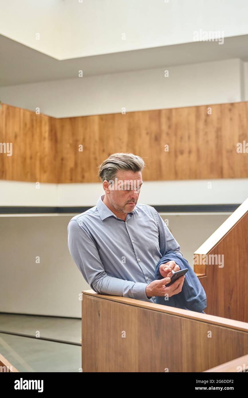 Concepteur dans son espace de travail vérifiant son smartphone pendant son temps de repos Banque D'Images