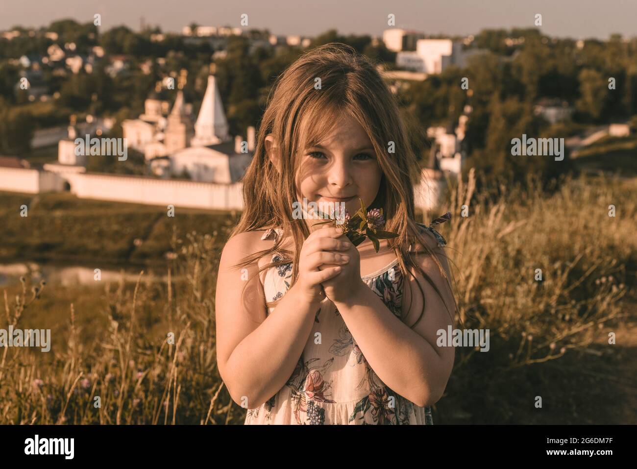 Une petite fille dans le champ avec ses mains dans l'air. Photo de haute qualité Banque D'Images