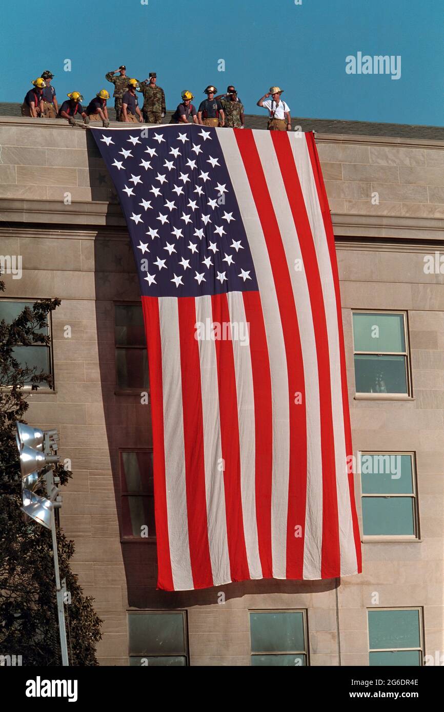 Les pompiers déploient un grand drapeau américain sur la pierre marqué du Pentagone Mercredi, 12 septembre 2001 à Arlington, Va., photo de Paul Morse, gracieuseté de la George Bush Presidential Library Banque D'Images