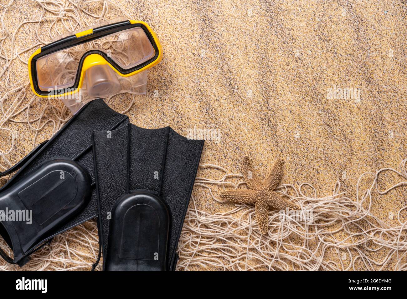 fond de sable avec nageoires, masque de plongée, filet de pêche et étoiles de mer pour le concept de vacances Banque D'Images