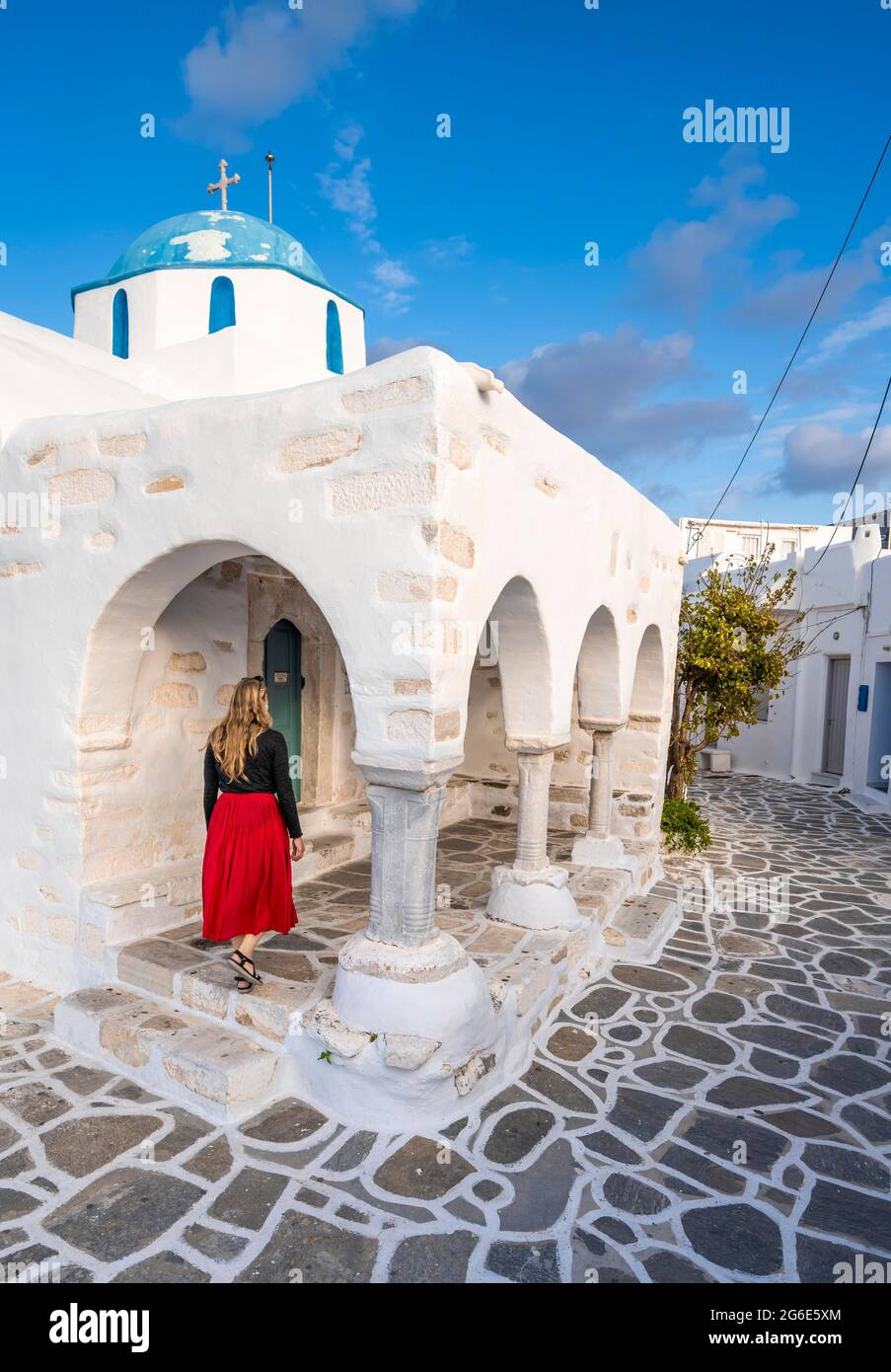 Tourisme avec robe rouge, Église grecque orthodoxe bleue et blanche Agios Nikolaos, Parikia, Paros, Cyclades, Mer Egéé, Grèce Banque D'Images