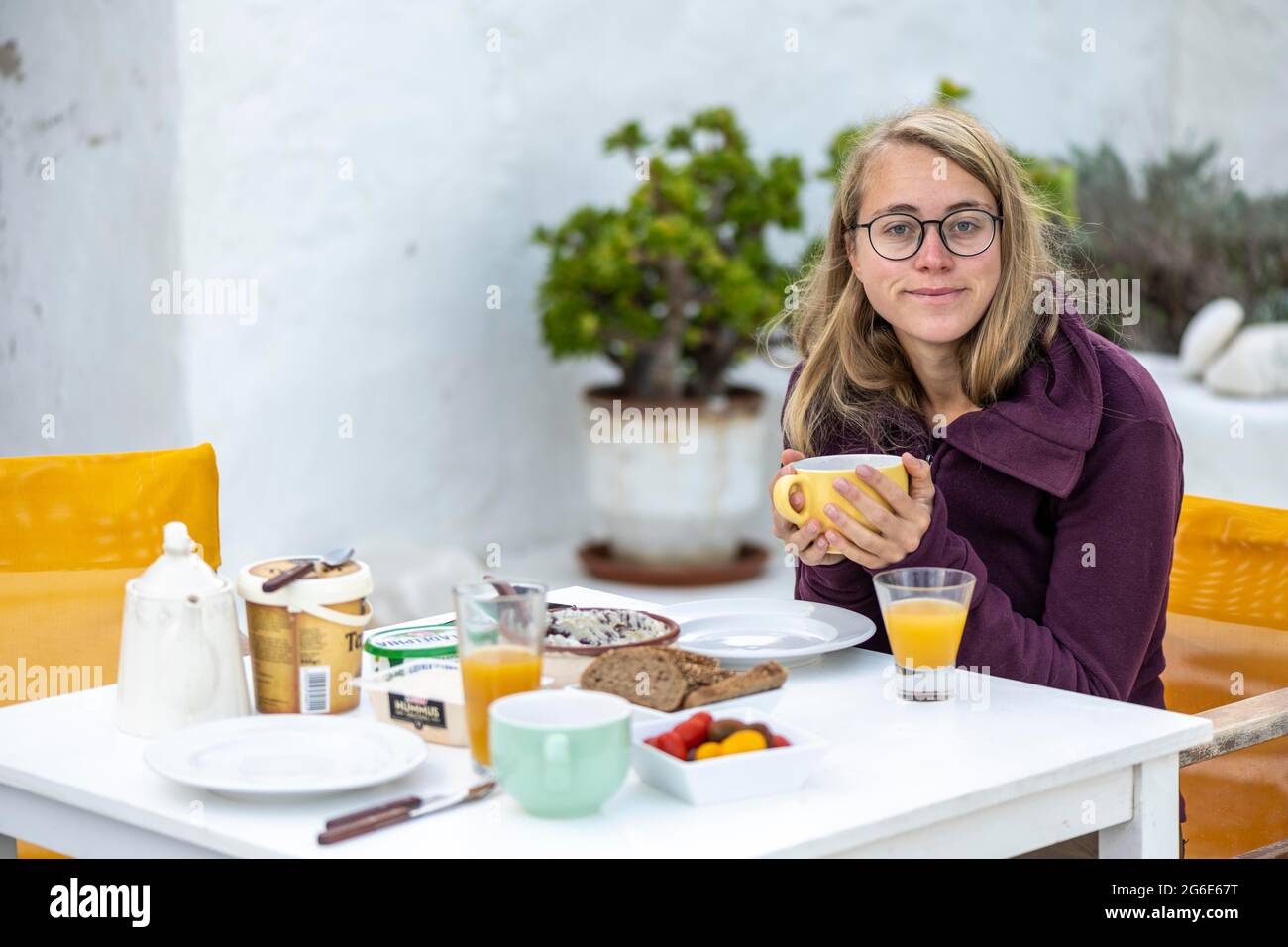 Jeune femme prenant le petit déjeuner, Grèce Banque D'Images