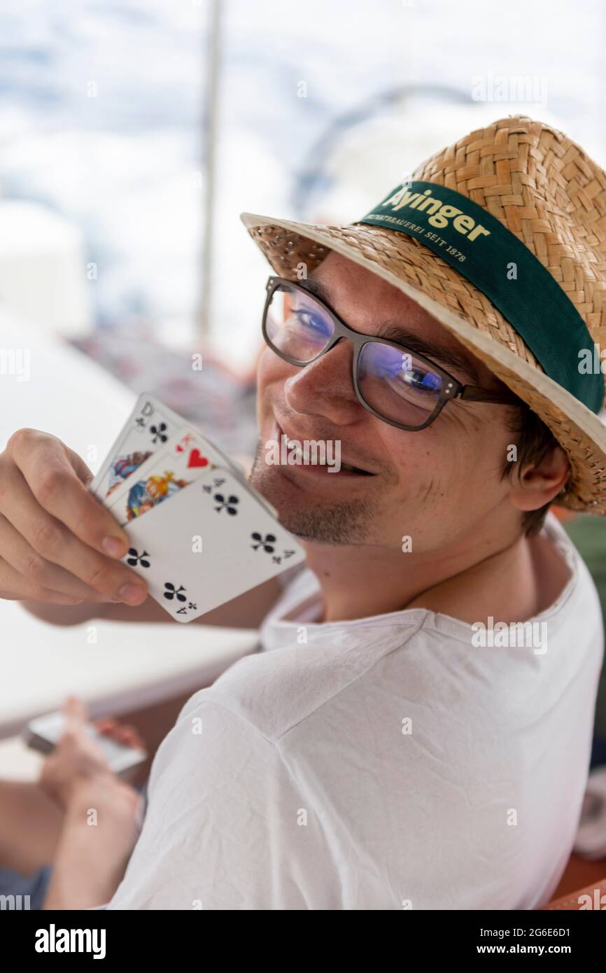 Le jeune homme grins et montre des cartes à jouer, jeu de cartes, jeux de société Banque D'Images