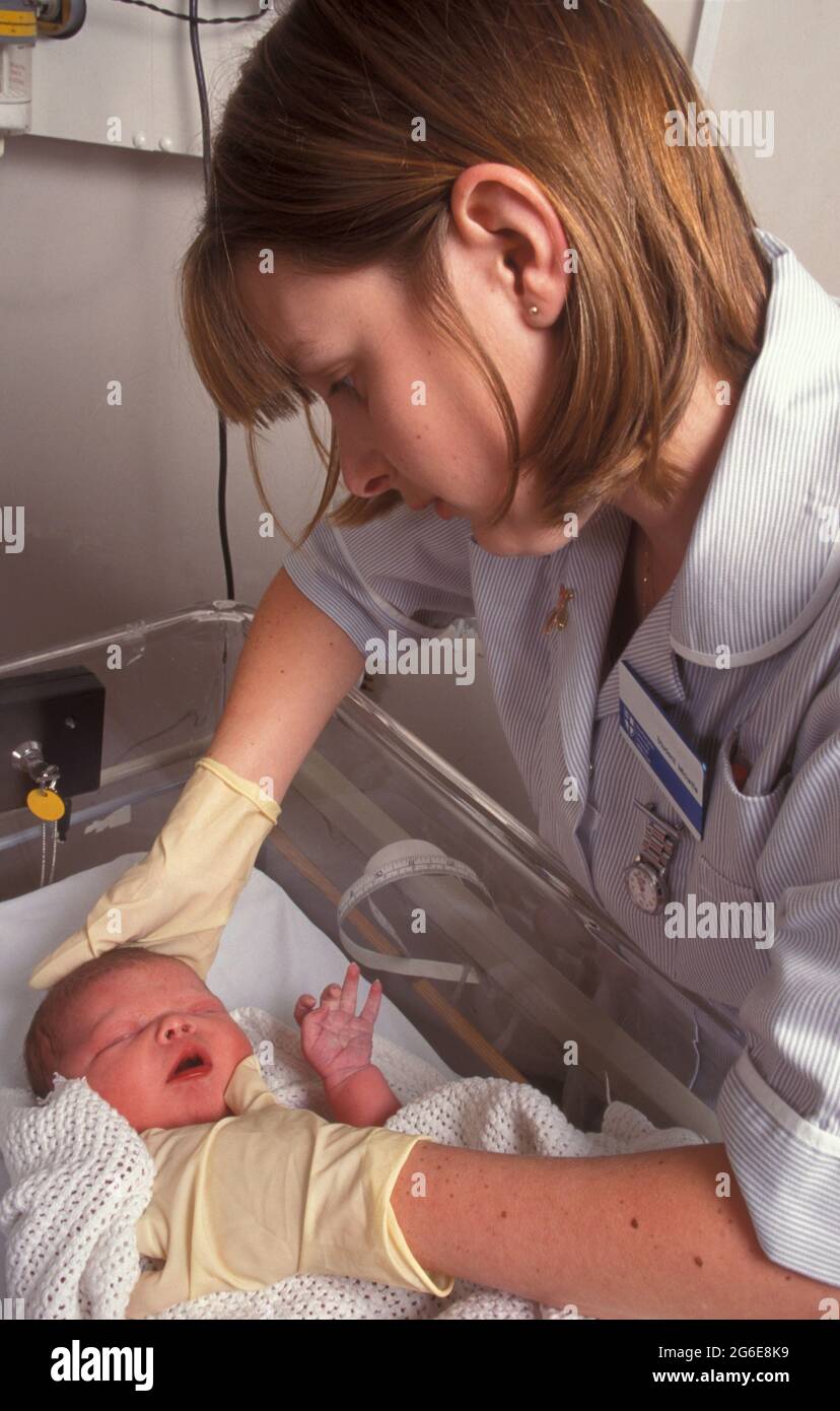 jeune sage-femme effectuant des contrôles ante natals (fontanelle) sur bébé nouveau-né Banque D'Images