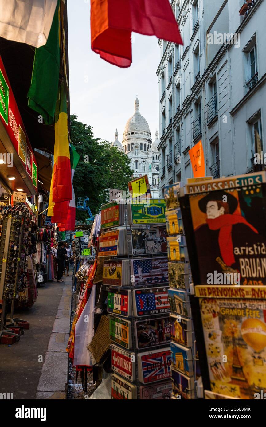 Rue avec boutiques de souvenirs à Montmartre et basilique du Sacré-cœur en arrière-plan, Paris, France Banque D'Images