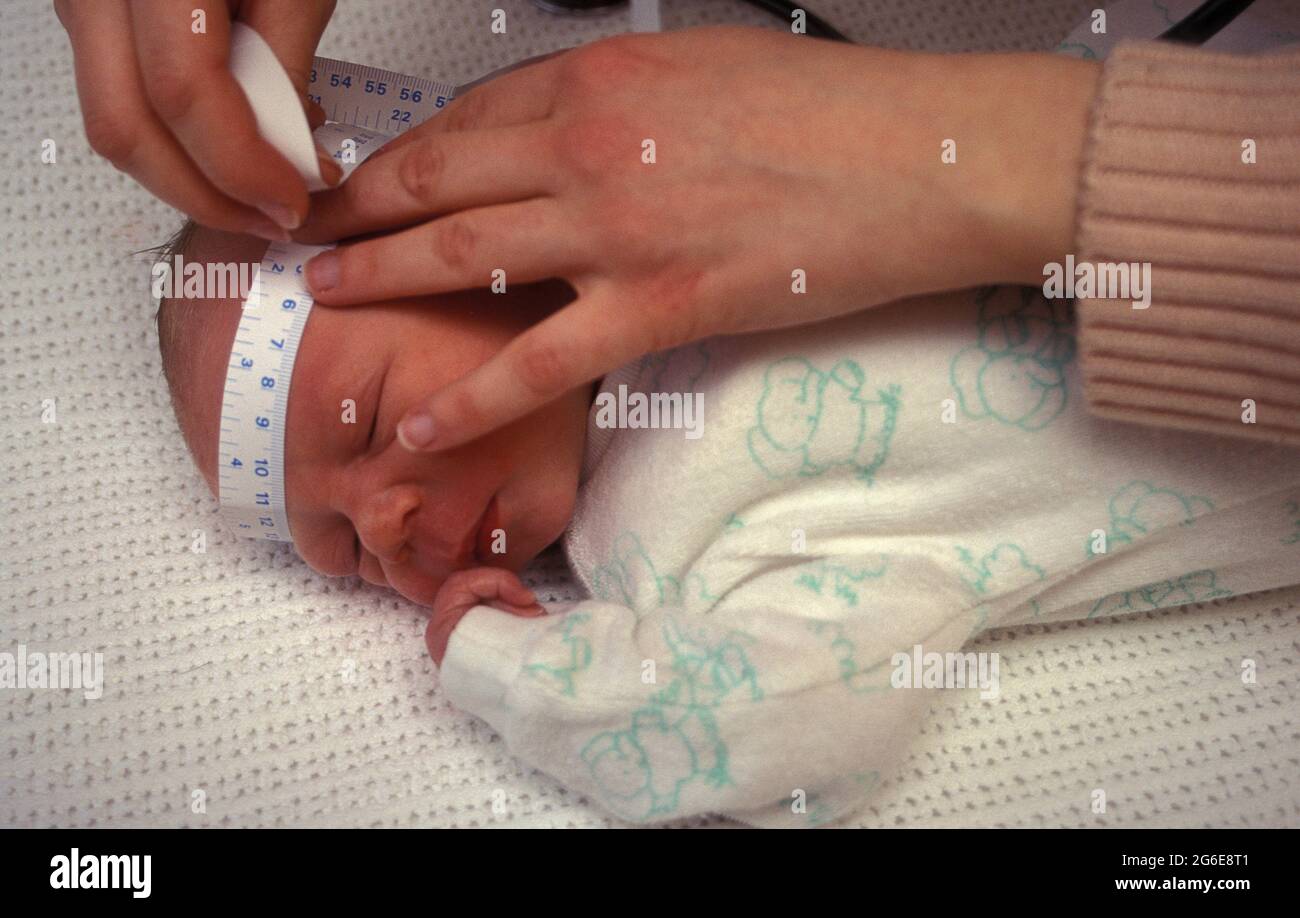 le pédiatre mesure la circonférence de la tête de bébé du nouveau-né Banque D'Images