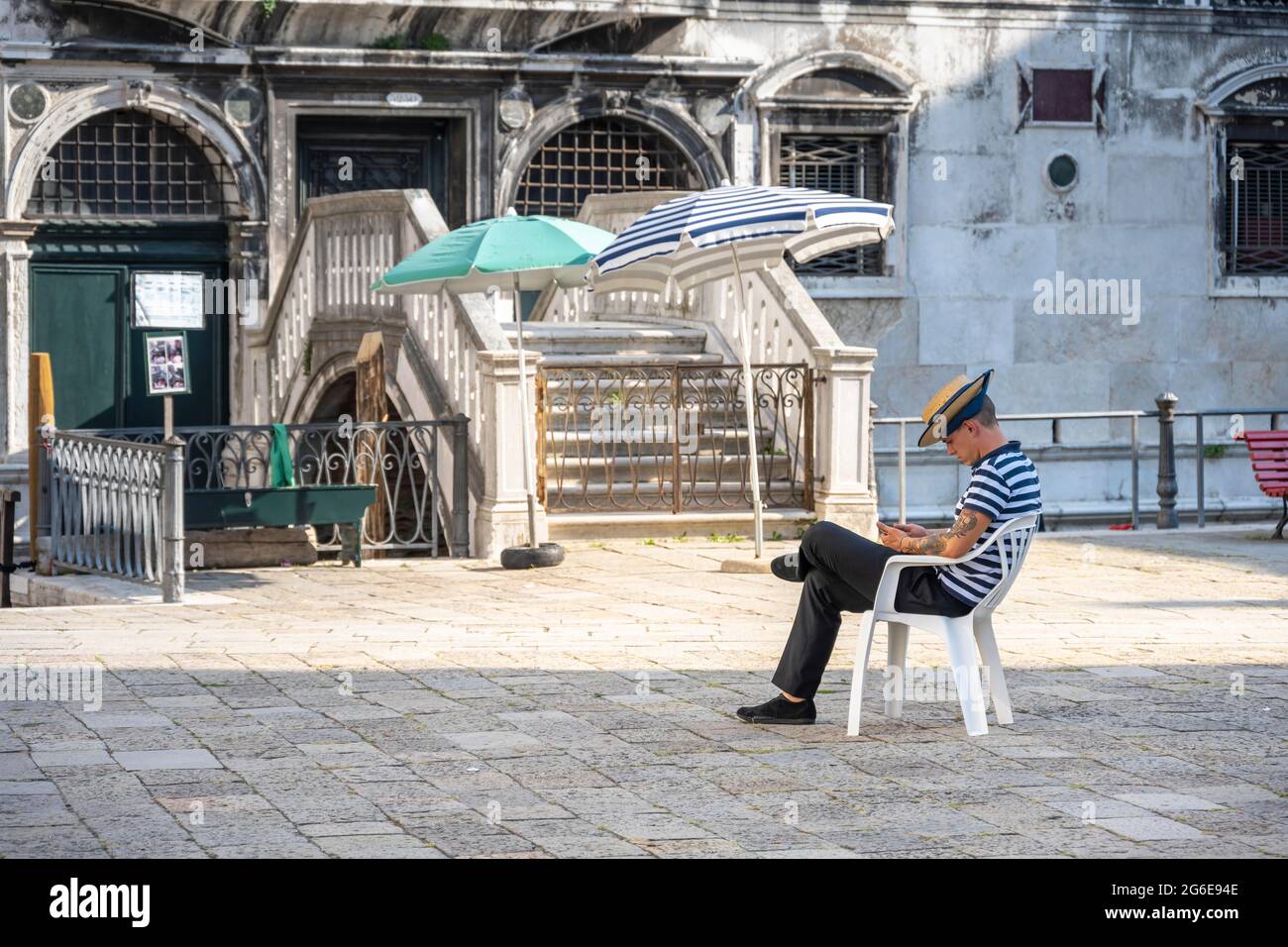 Gondolieri assis sur une chaise sur une place, Venise, Vénétie, Italie Banque D'Images