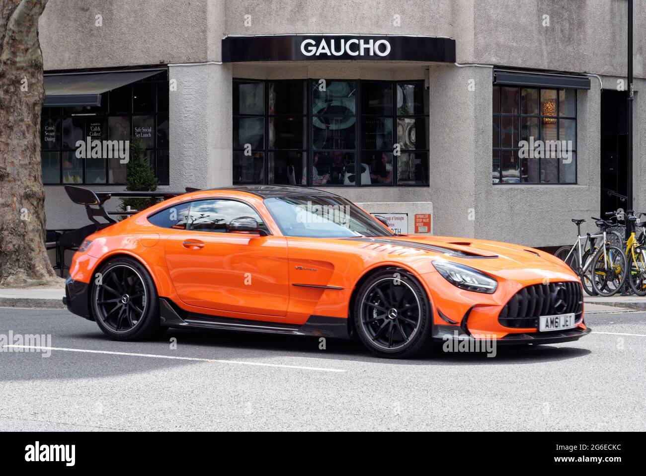 Londres, Grand Londres, Angleterre - juin 12 2021 : voiture de sport Mercedes orange et noire avec un grand plus grand spolier conduit dans une rue. Banque D'Images