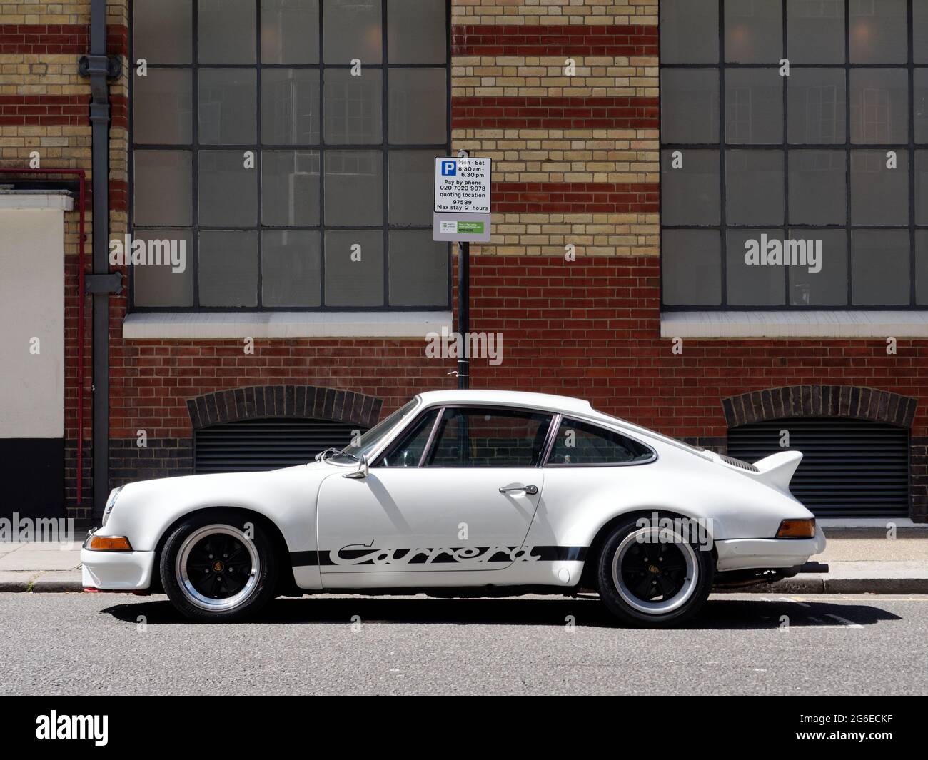 Londres, Grand Londres, Angleterre - juin 12 2021 : Porsche Carrera blanche et noire garée dans une rue avec un panneau de stationnement derrière. Banque D'Images