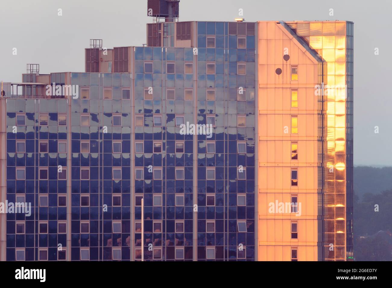 Le soleil couchant fait tourner les fenêtres de Churchill place, un immeuble d'appartements en hauteur, orange foncé à la fin juin. Basingstoke, Royaume-Uni Banque D'Images