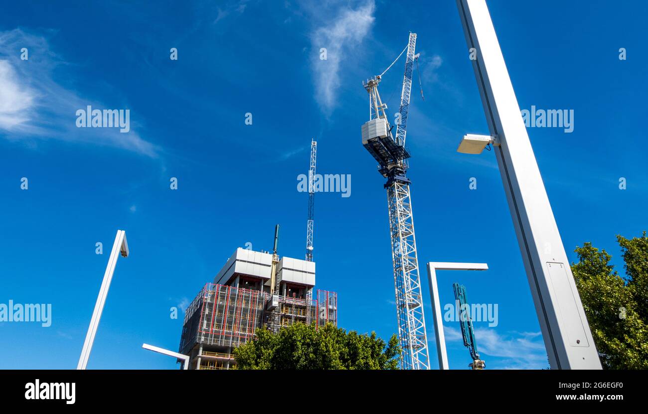 Construction moderne abstraite et grues contre ciel bleu Banque D'Images